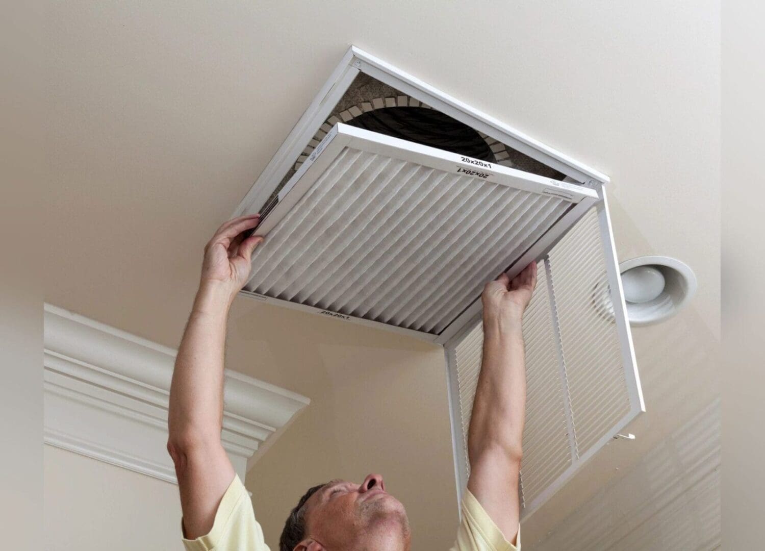 A man performing a DIY installation of an air conditioner in a room.