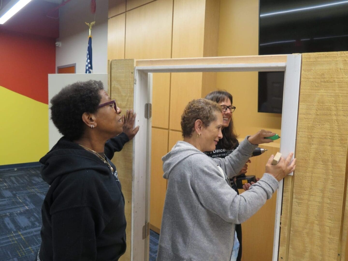 A group of people working on a door in a gallery room.