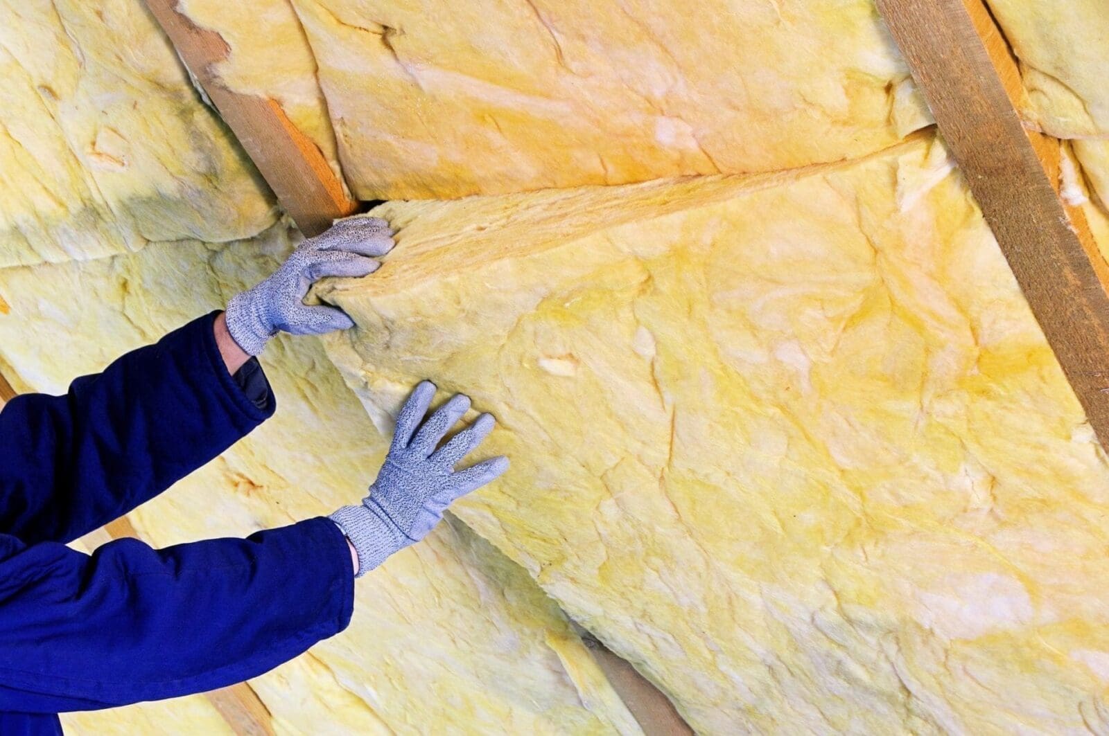 A Do It Yourself enthusiast is putting insulation on a wall.