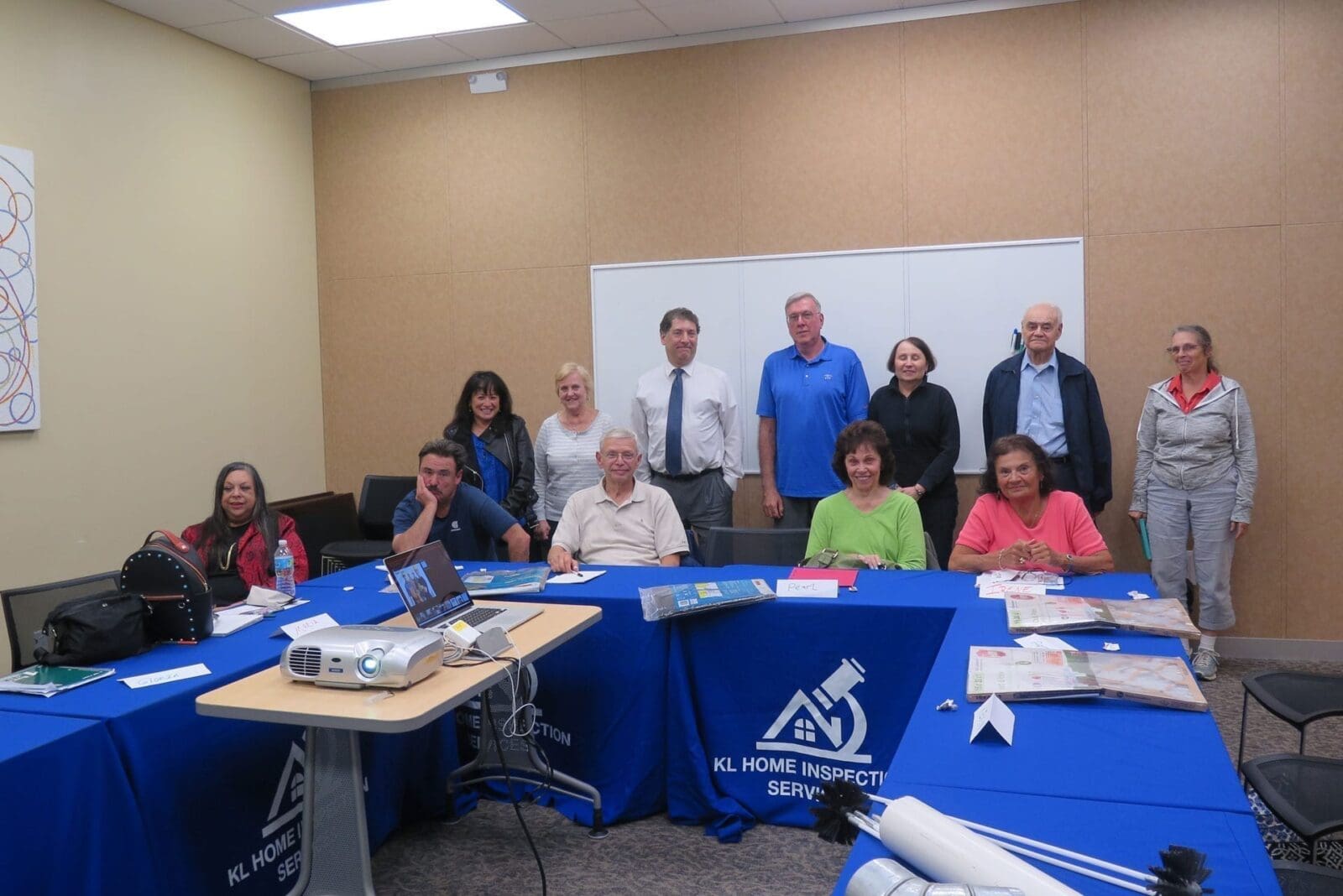 Improve your home improvement skills with a group of people posing in front of a blue table.