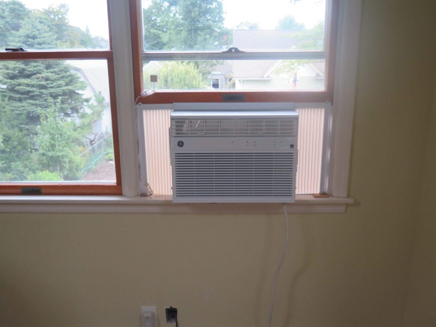 An air conditioner sitting on a window sill.